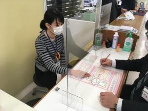 窓口で飛沫防止パネルを使用している写真